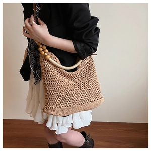Detailed macro view of hollow knit texture with wooden bead accents on a summer beach bag