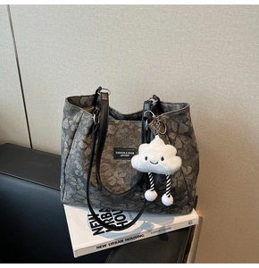 Détail du sac cabas en jacquard avec motifs floraux vintage et breloque nuage doux