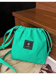 Vibrant green drawstring bucket bag made of durable nylon with adjustable shoulder strap
