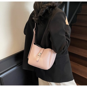 Vue arrière du mannequin portant un sac seau rose pâle avec boucle en métal argenté