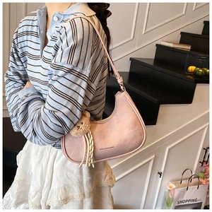 Pink crescent underarm bag with cute teddy bear charm and striped cord detail