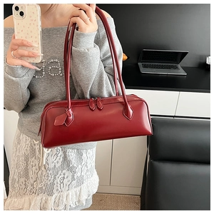 Close-up of deep red rectangle baguette bag showing smooth matte leather and double zippers