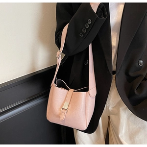 Détail du sac seau en cuir grainé rose tendre avec boucle argentée et bandoulière réglable