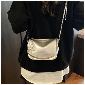 Detail of silver metallic crossbody bag with chain strap and balloon dog charm