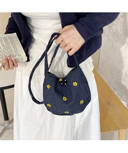 Détail du sac à main en denim bleu marine avec broderie florale jaune et fermoir boule