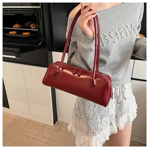 Detailed view of dark red leather baguette bag with dual slim straps and metallic zipper