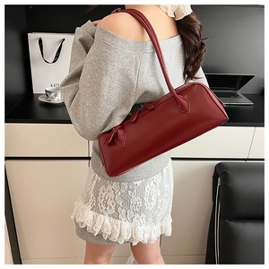 Detail view of a vintage dark red rectangular leather baguette bag worn by a model