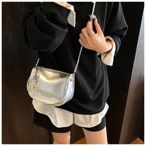 Silver metallic crossbody bag featuring a chain strap and cute balloon dog charm detail