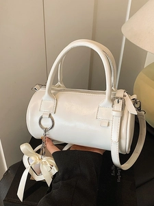 Borsa a cilindro bianca con manici e ciondolo a cuore mostrata in un contesto lifestyle