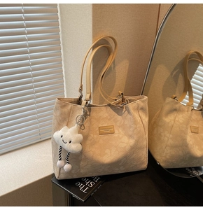 Détail du grand sac cabas beige avec motifs floraux et charm nuage en peluche doux