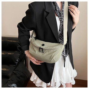 Detail of green crescent crossbody bag with nylon texture and adjustable beige strap
