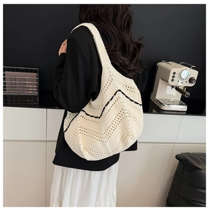 Détail du sac cabas en maille avec texture ajourée et motif à vagues noires sur beige