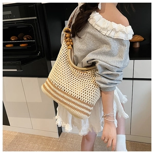 Detail of summer crochet hobo bag with brown stripes and decorative wooden beads