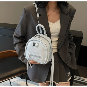 Close-up of light blue mini backpack with silver metal hardware on a grey blazer