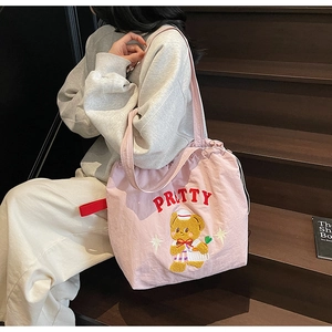 Detail of pink canvas tote bag featuring 3D flocked bear embroidery and drawstring closure