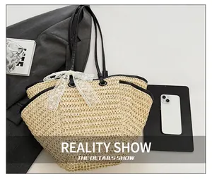 Détail du sac cabas en paille avec bordure en similicuir noir et nœud en dentelle