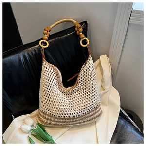 Detail of crochet beach bag with wooden beads and golden metal arc handle in boho style