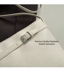 Detail of silver pin buckle and lychee textured cream leather on luxury bucket bag