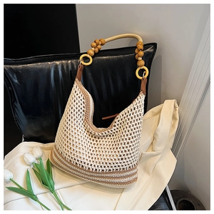 Detail of hand-woven shoulder bag with ivory mesh, wooden beads, and golden handle