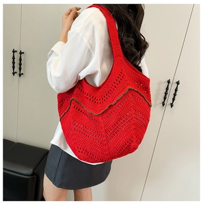 Détail d'un sac cabas en tricot rouge ajouré avec des motifs géométriques au crochet doux