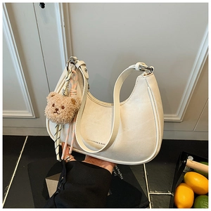 Detail view of cream hobo bag with teddy bear charm and BAFANSHA logo print