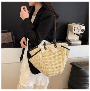 Détail du sac cabas en paille beige avec bordure en cuir noir et nœud en dentelle