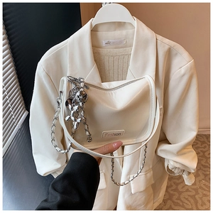 Close-up of a white textured crossbody bag with silver chain and a balloon dog charm