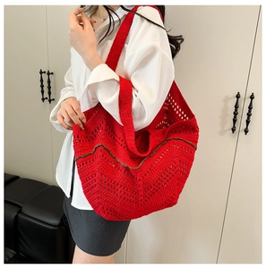Détail d'un sac cabas en crochet rouge avec tricot ajouré et bande verte décorative