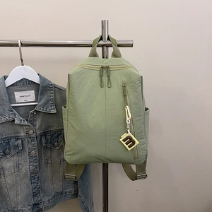 Detail of pea green nylon backpack with smooth texture and stylish letter m pendant