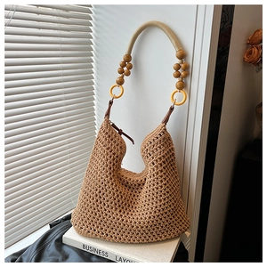 Detail of woven beach tote with wooden bead handle and yellow rings on a white frame