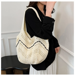 Détail du sac cabas en tricot avec tissage ajouré crème et motif ondulé noir