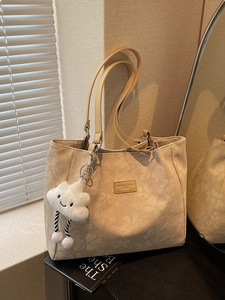 Sac cabas beige chic avec imprimé fleuri et pendentif nuage sur fond minimaliste
