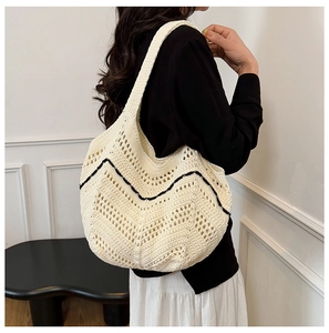 Détail du sac cabas au crochet montrant la texture ajourée et les accents noirs ondulés