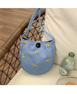Gros plan d'un sac à main rond en jean bleu avec broderie florale jaune et fermeture à bouton