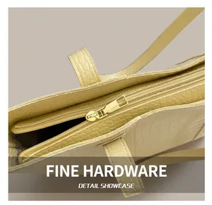 Close-up of golden metal zipper and crocodile pattern texture on yellow tote bag