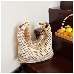 Detail of hand-woven crochet bucket bag with multi-color wooden beads and mesh texture