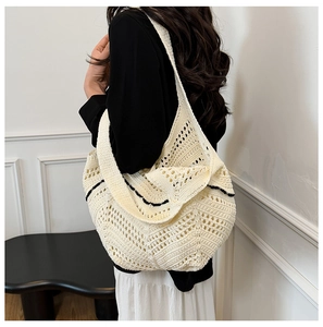 Détail du sac cabas en tricot ajouré blanc crème avec bordure ondulée noire élégante