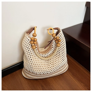 Detailed close-up of bohemian hollow knit bag with wooden beads and leather handle