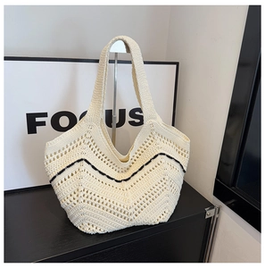 Détail du sac cabas en tricot ajouré montrant le motif en V noir sur fond beige