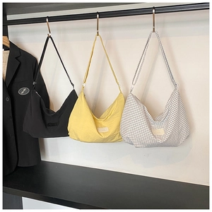 Three colors of nylon crossbody bags shown in black, yellow, and grey plaid patterns