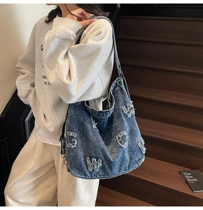 Retro denim shoulder bag with letter patches and distressed details in street style