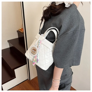 Detailed back view of white quilted crossbody bag with a cute Capybara charm hanging