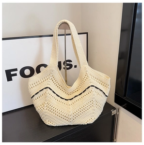 Détail du sac cabas en crochet beige montrant la texture en maille et le motif à vagues noires
