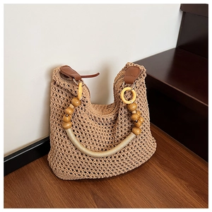 Detail of handwoven crochet bucket bag featuring artistic beaded handle and textured pattern