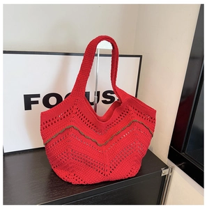 Détail d'un sac cabas en tricot rouge avec motif vagues vertes et anses tissées