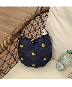 Détails de broderie florale sur un sac en denim bleu avec bouton à pois décoratif