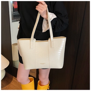 Detailed view of cream crocodile embossed leather tote bag with sturdy double handles