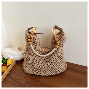 Detail of hand-woven beige tote with decorative wooden beads and leather strap accents