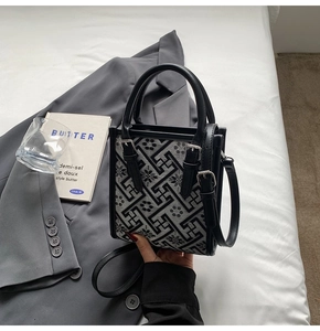 Détail du sac bandoulière bohème à motif géométrique et brides en cuir sur veste grise