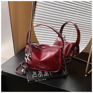 Deep red vintage leather crossbody bag with chain strap and cute balloon dog charm